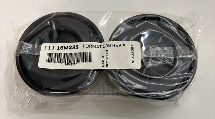Two black circular respirator cartridges sealed in clear plastic packaging with a white barcode label and batch information from Honeywell.