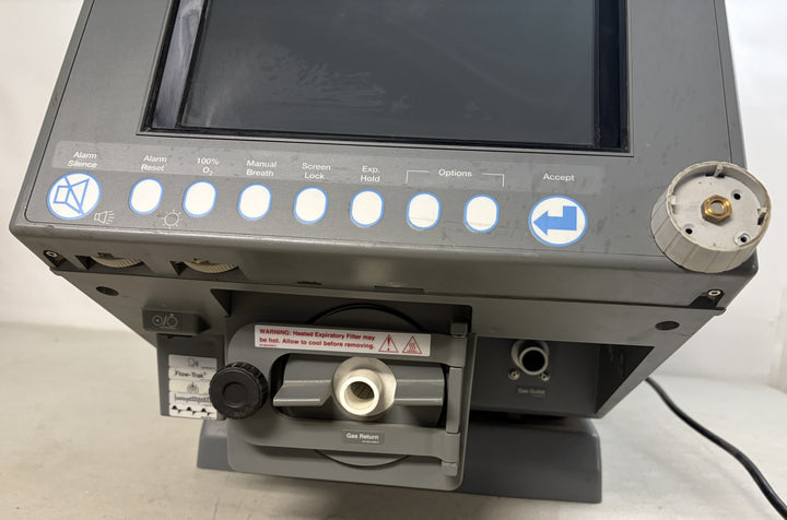 Close-up view of a Philips Respironics medical equipment core unit featuring control buttons below a blank screen and a connector port on a gray base surface.