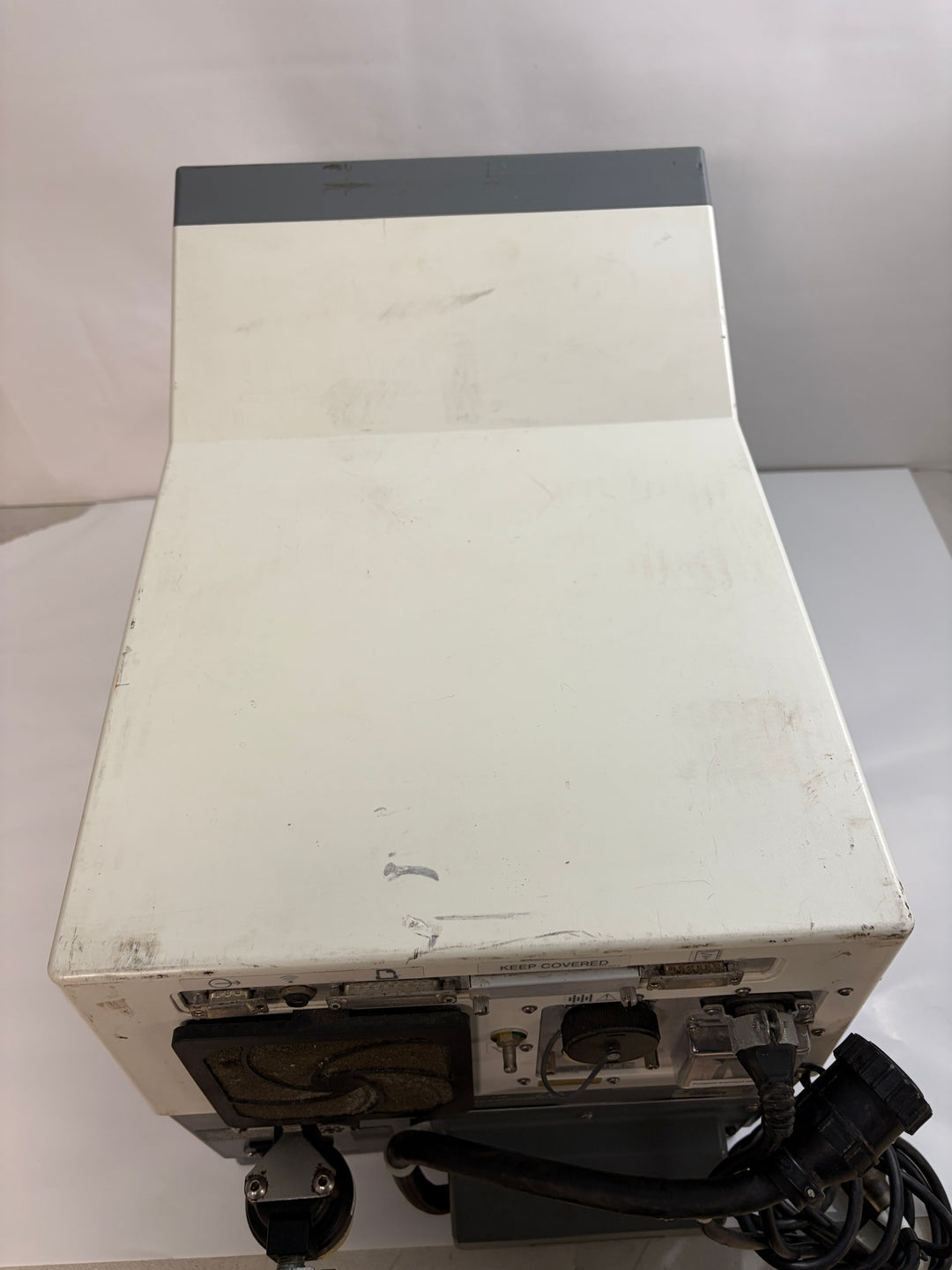 White and gray Philips Respironics medical device core unit for repair with visible wear and attached cables on a neutral surface.