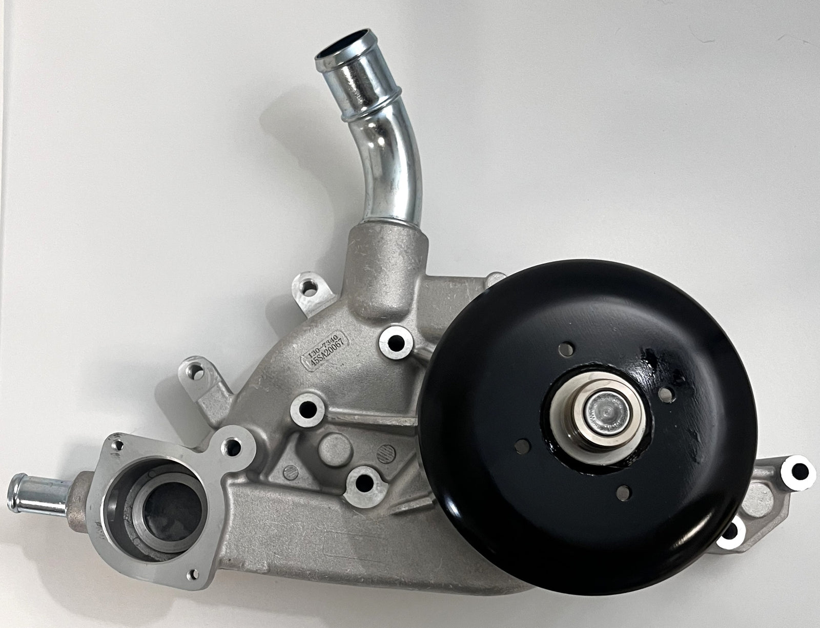 Engine water pump with silver cast metal housing and black pulley, featuring multiple mounting points and fluid inlet tubes, designed for automotive cooling systems by NAPA.