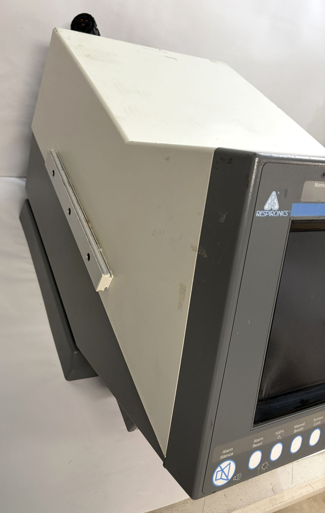 Close-up angled view of a Philips Respironics core unit for medical equipment repair, featuring a blank screen and gray casing with visible wear marks.