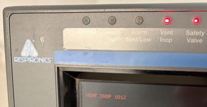 Close-up of a Philips Respironics medical device panel with warning lights illuminated and the display showing “VENT INOP 1012” indicating a ventilation malfunction alert.