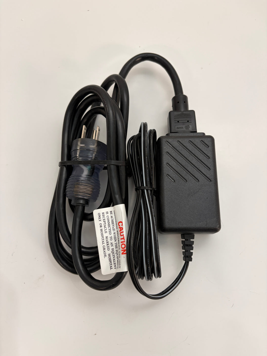 Power adapter with a caution label on a white background