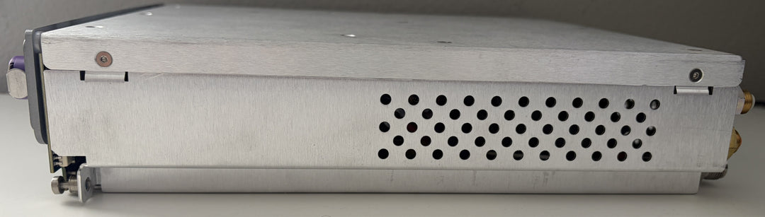 Rectangular metal device with a perforated cover on a gray background