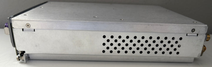Metallic electronic device with a perforated cover on a gray background