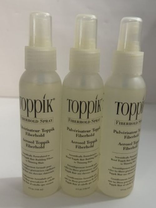Three clear spray bottles of Toppik aerosol fiberhold spray arranged side by side with white caps and labels on a plain white background