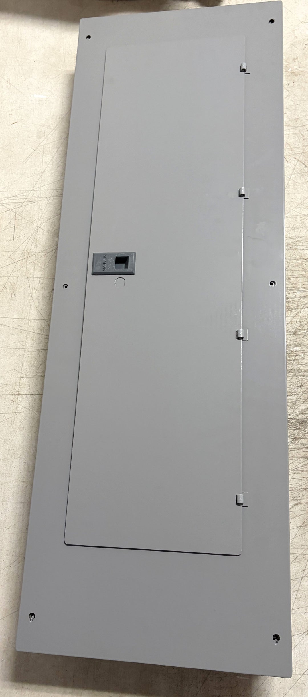 Siemens gray metal electrical load center panel with closed door and latch, designed for indoor use in residential or commercial electrical installations.