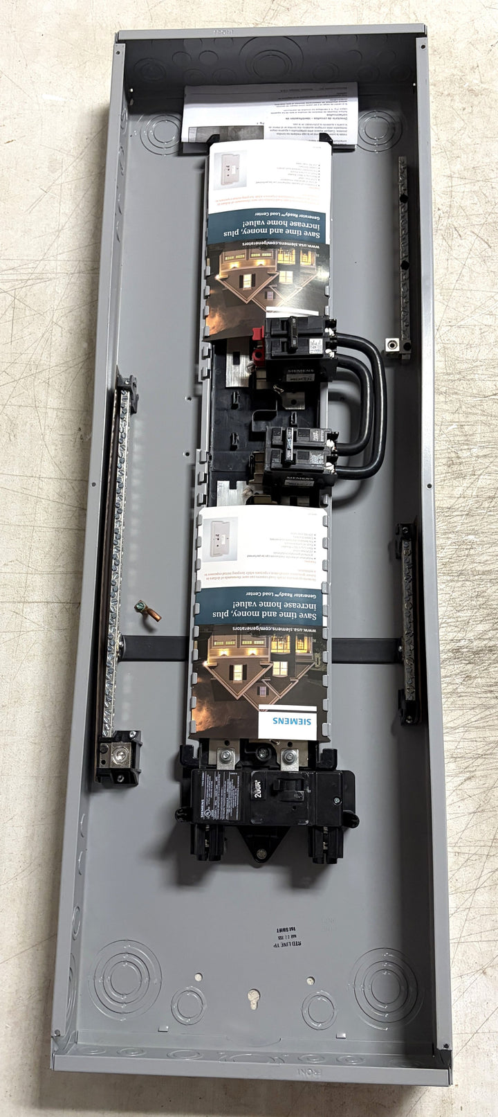 Siemens electrical load center panel with circuit breakers and labels inside a grey metal enclosure, designed for indoor generator connection and electrical distribution.