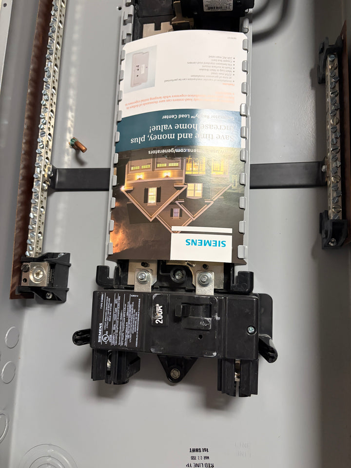 Siemens 200 Amp electrical load center breaker installed inside a metal panel with neutral and ground bus bars visible around the unit.