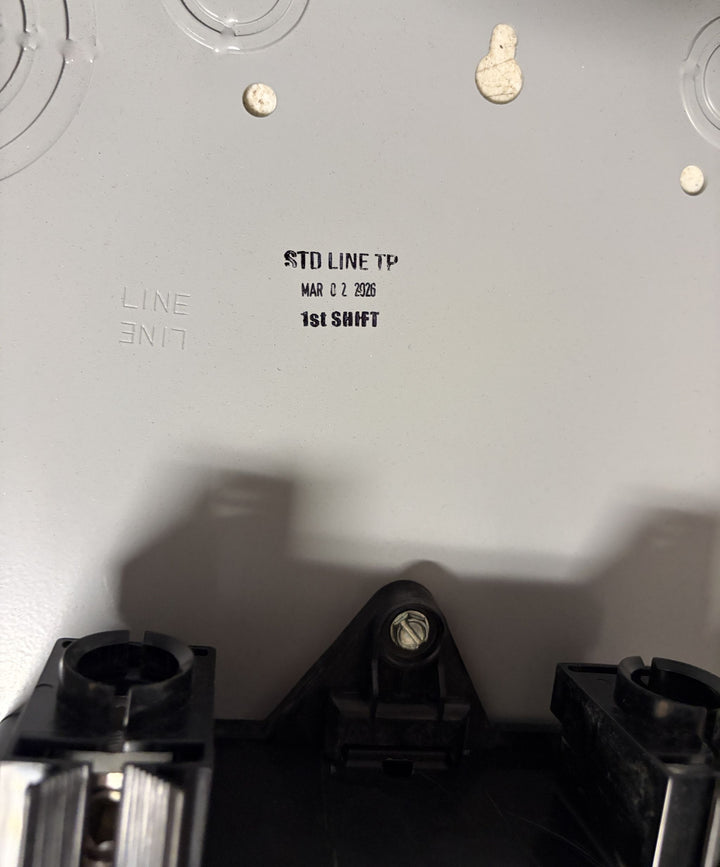 Interior view of a Siemens electrical panel showing stamped production details and mounting hardware on a light gray metal surface.