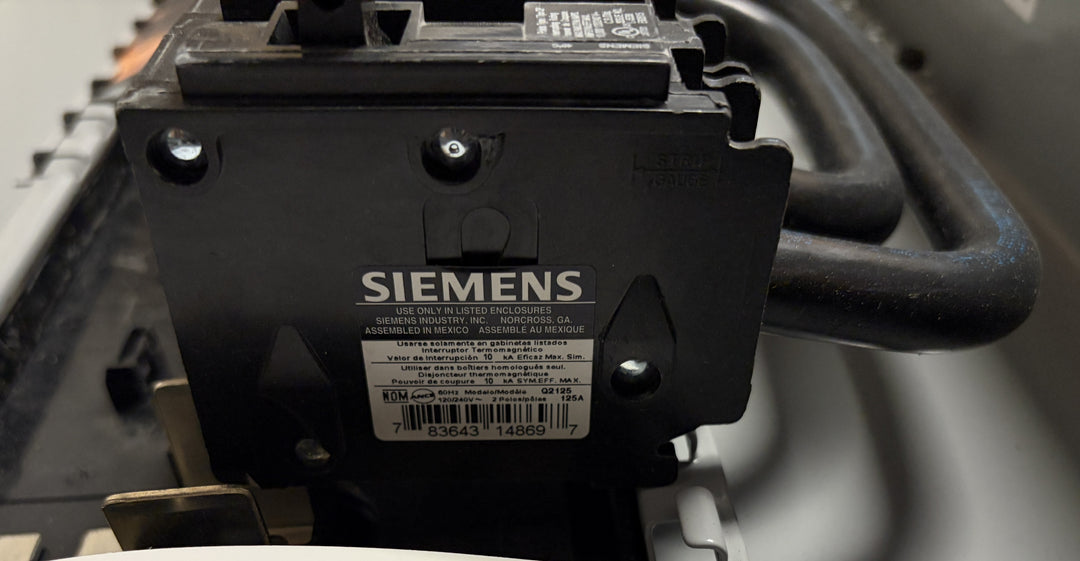 Close-up view of a Siemens electrical component featuring a label with product details, mounted inside a generator ready load center enclosure.