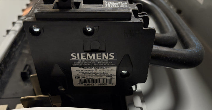 Close-up view of a Siemens electrical component featuring a label with product details, mounted inside a generator ready load center enclosure.