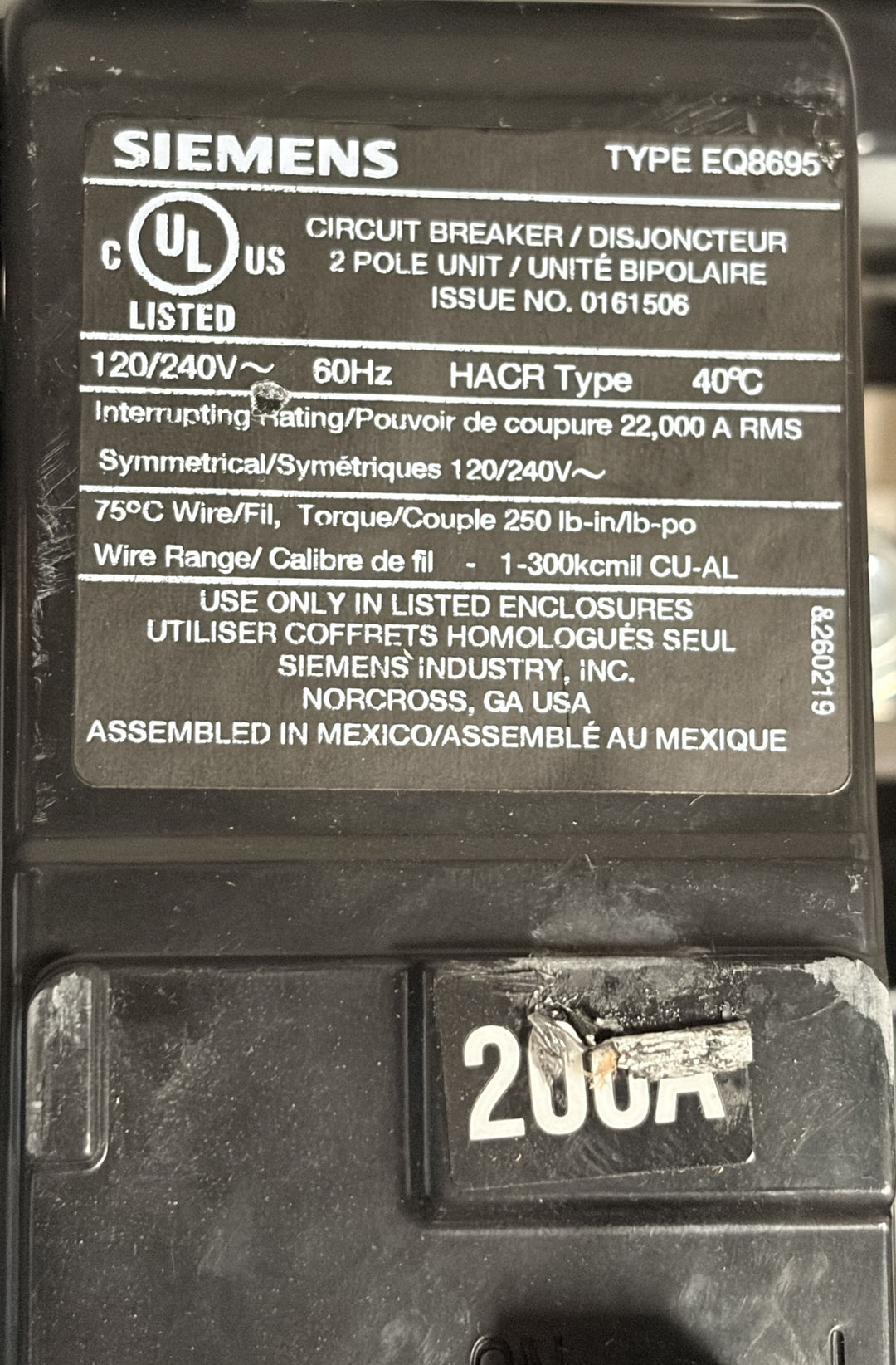 Close-up of a Siemens circuit breaker label showing electrical specifications, UL certification, and a damaged 200 amp breaker switch on a black electrical component.