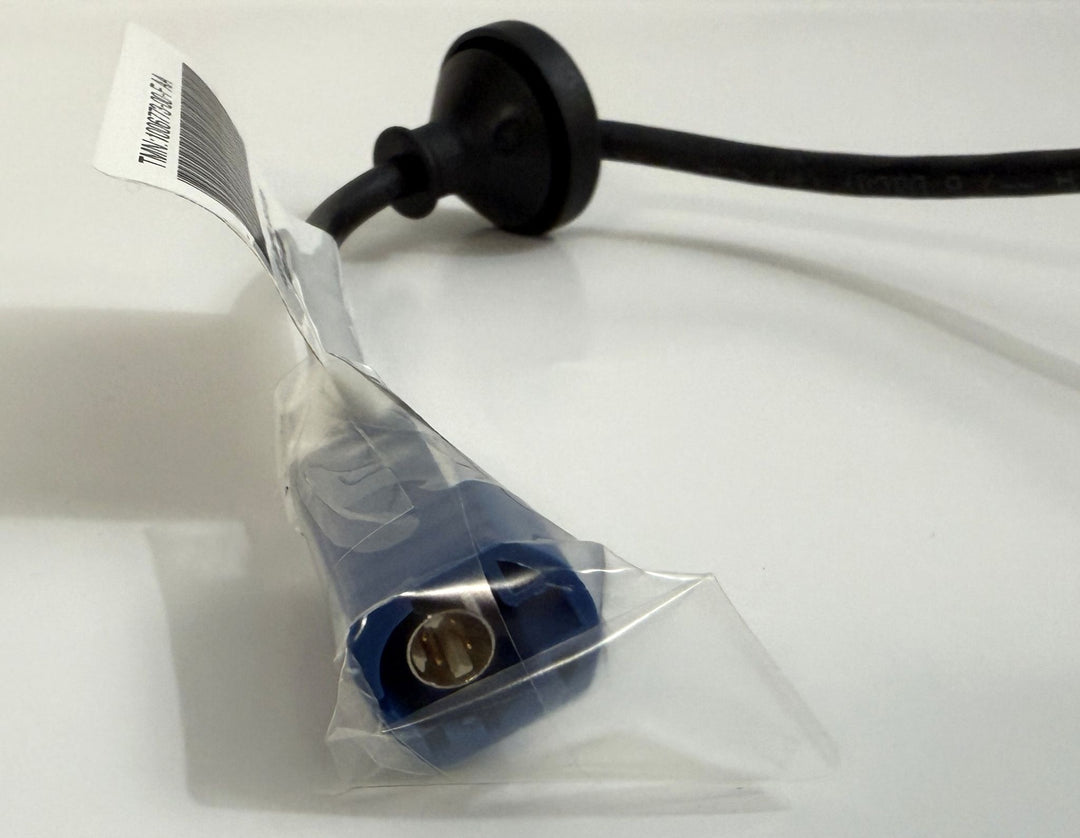 Close-up of a Tesla genuine OEM rear view backup camera harness assembly with a blue connector partially wrapped in clear protective plastic on a white surface.