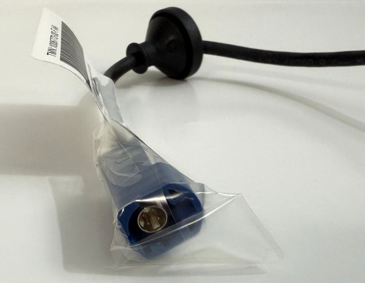 Close-up of a Tesla genuine OEM rear view backup camera harness assembly with a blue connector partially wrapped in clear protective plastic on a white surface.