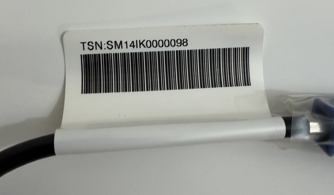 Close-up of a cable with a white label featuring a barcode and the identifier TSN:SM141K0000098, part of a Tesla Model S rear view camera harness assembly.