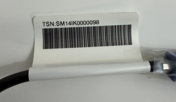 Close-up of a cable with a white label featuring a barcode and the identifier TSN:SM141K0000098, part of a Tesla Model S rear view camera harness assembly.