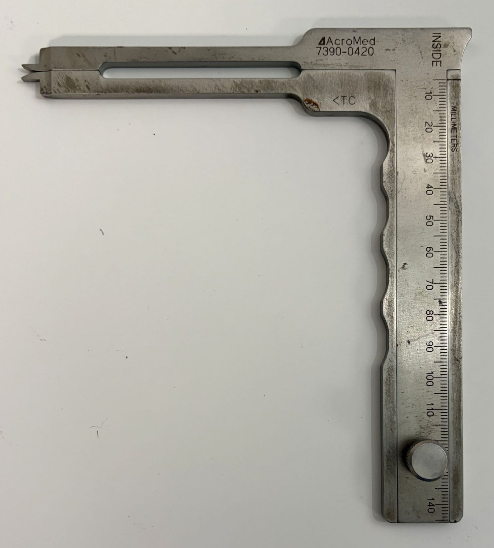 AcroMed stainless steel caliper spreader with engraved measurement scale and adjustable sliding arm, designed for precise pedicle distance measurement in medical applications.