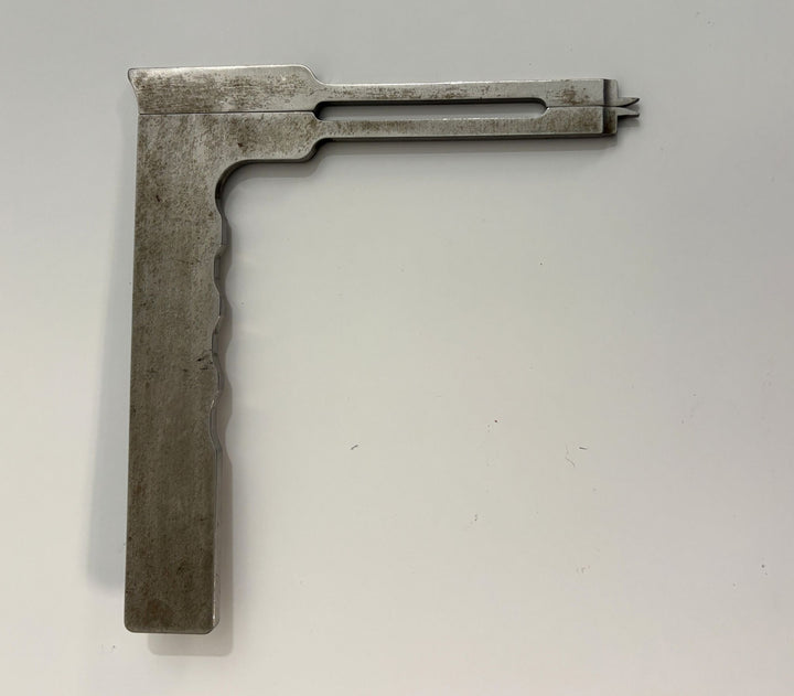 Metal caliper tool with a sliding measurement arm and notched adjustment end, used in medical or industrial applications, from AcroMed.