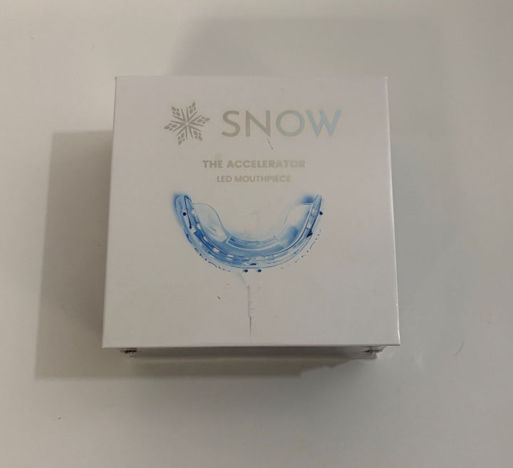 Snow branded LED mouthpiece for teeth whitening, featuring a sleek design and packaging highlighting its use as a dental accelerator device.