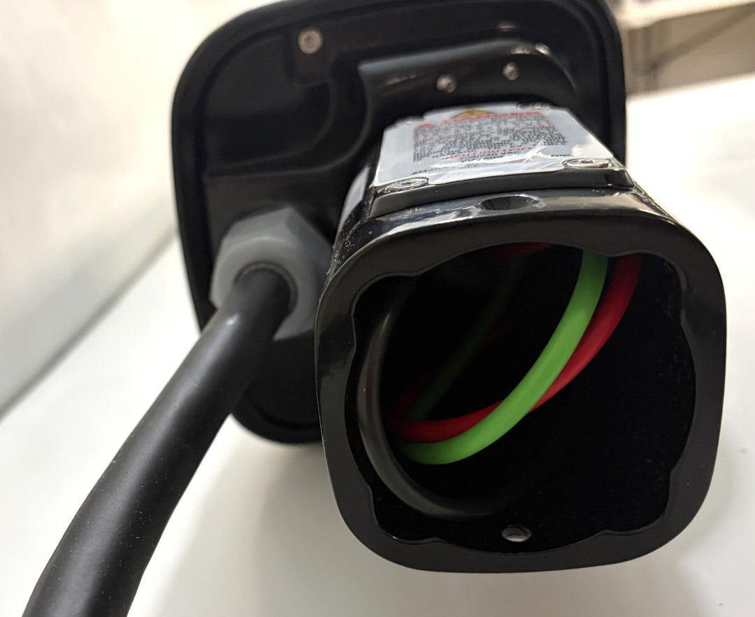 Close-up view of the connector end of a SemaConnect 630 Level 2 EV charging station, showing internal wiring with red and green cables inside a black housing.