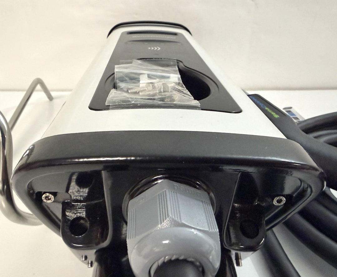 Close-up view of a SemaConnect commercial-grade Level 2 electric vehicle charging station connector with attached cable and mounting hardware on a plain background.