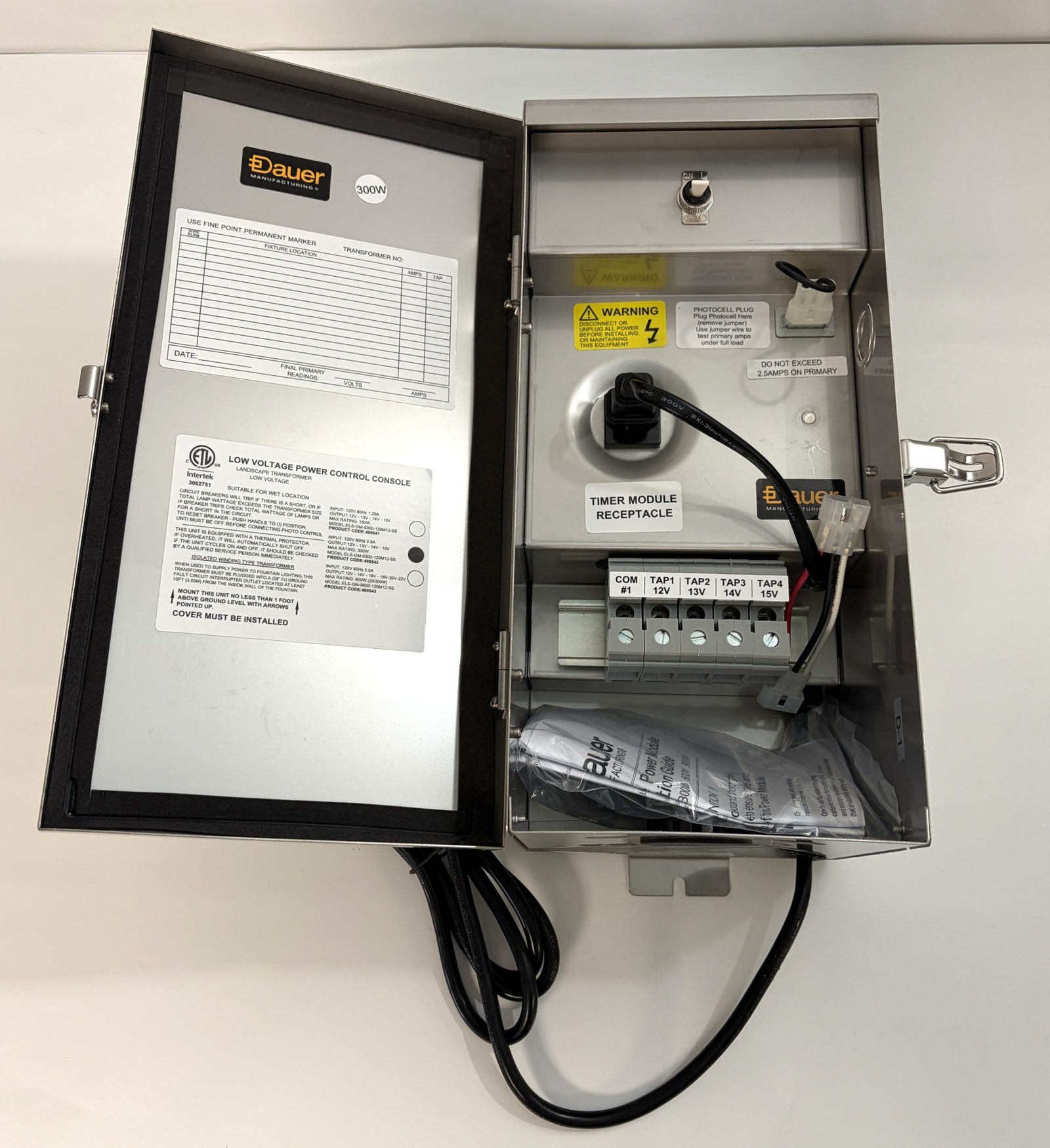 Open Dauer stainless steel electrical transformer enclosure showing internal wiring terminals, warning labels, timer module receptacle, and product information on the door panel.
