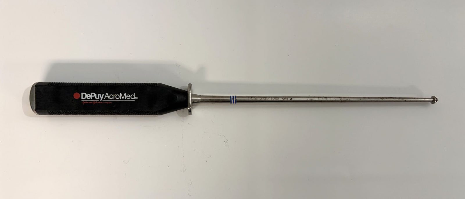 Surgical instrument with black handle branded by Depuy AcroMed and a long slender metal shaft designed for precise spinal insertion during medical procedures.