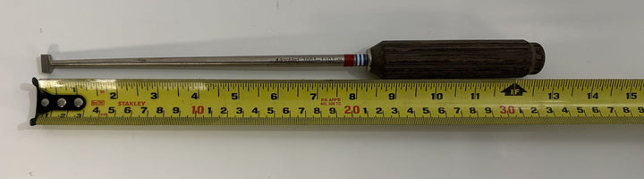 AcroMed bone graft impactor with a polished metal shaft and a dark wooden handle, shown next to a measuring tape for size reference.
