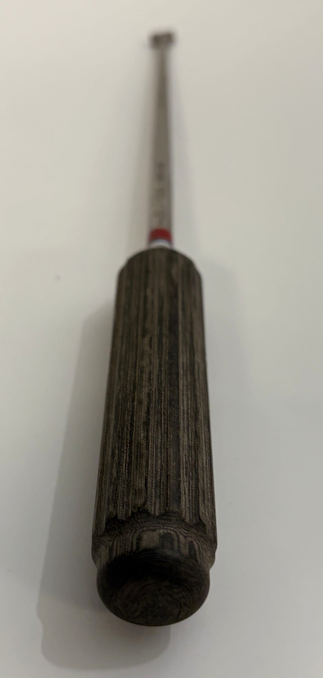 Close-up of a surgical bone graft impactor with a textured dark handle and metal shaft, designed for precise spinal procedures by AcroMed.