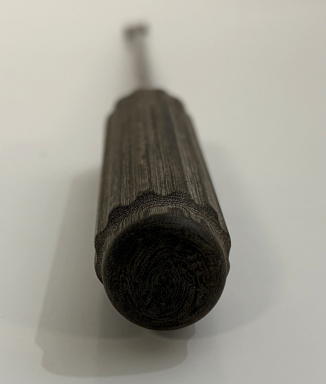 Close-up view of a textured dark handle on an AcroMed bone graft impactor, a precision spinal surgical instrument used in medical procedures.