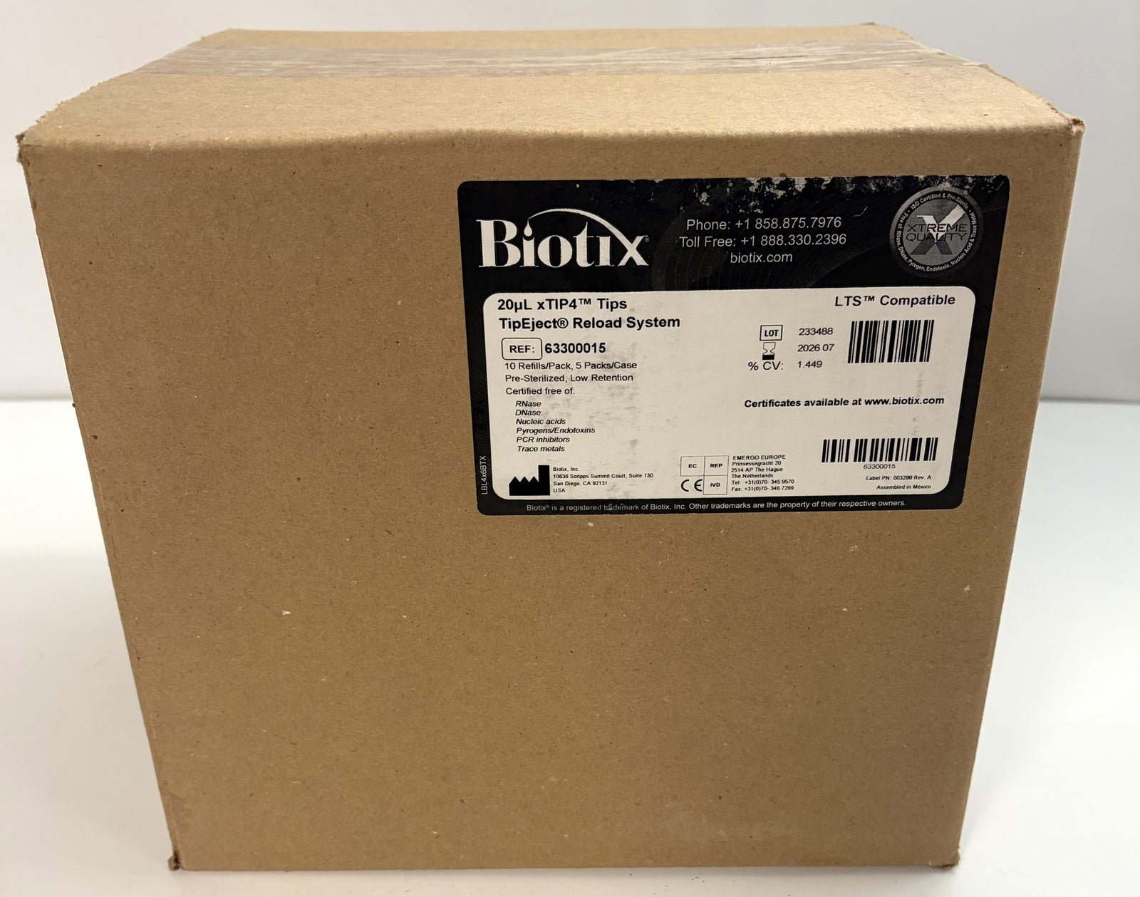Plain brown shipping box with a black and white Biotix label detailing a 20µL pipette tip eject reload system for laboratory use, compatible with LTS.