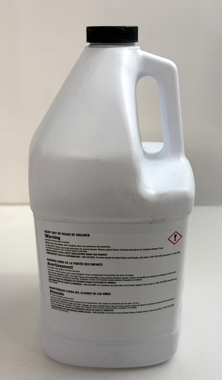 White plastic container with a black cap displaying safety warning labels in multiple languages, used for an industrial cleaning product by Ecolab.