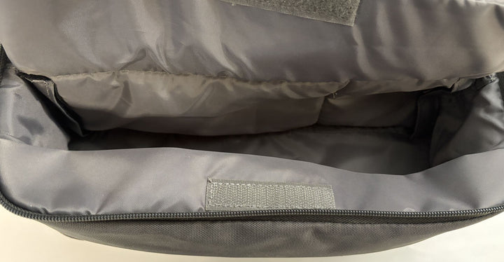 Interior view of a charcoal gray pre-owned Resmed travel bag for AirSense 10 CPAP device, showing padded compartments and fabric lining with a zipper opening.