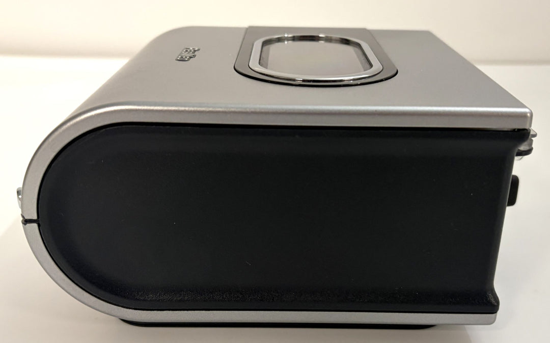 Side view of a pre-owned Resmed H5i humidifier component featuring a silver and black plastic casing, shown without accessories or attachments.