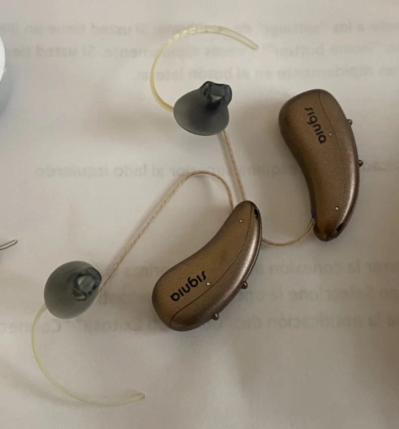 Two hearing aids on a light background