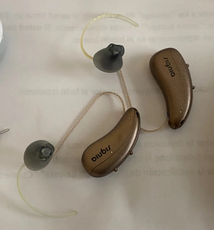 Two hearing aids on a light background