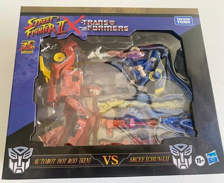 Action figures of Transformers Collaborative Street Fighter II Mash-Up: Hot Rod as Ken and Arcee as Chun-Li, in dynamic poses.