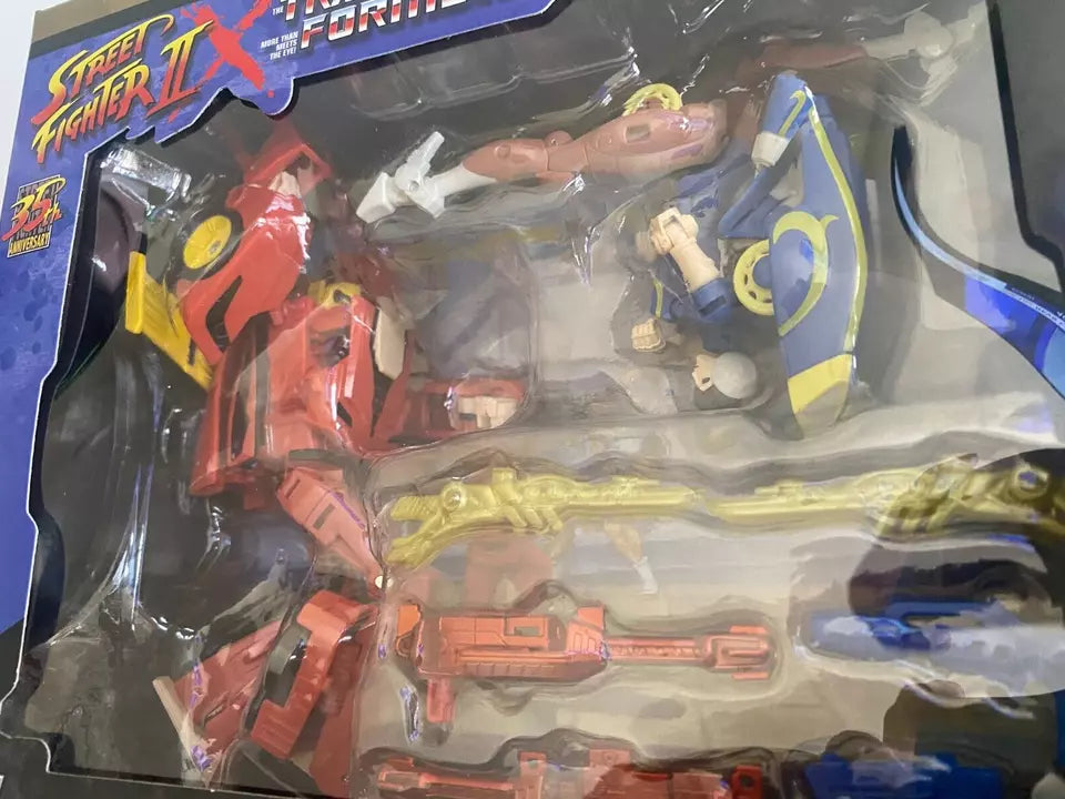 Action figures of Transformers Collaborative Street Fighter II Mash-Up: Hot Rod as Ken and Arcee as Chun-Li, in dynamic poses.